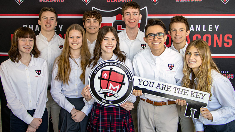 Group photo of graduating students with key sign